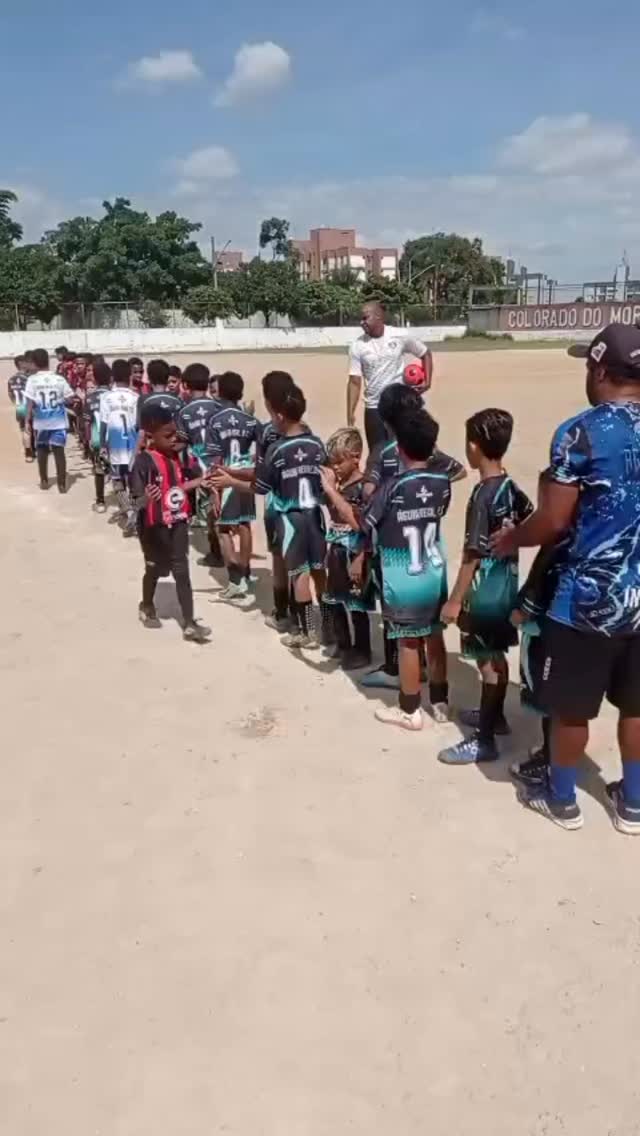Grupo de alunos da Escolinha Colorado do Morro reunidos no campo